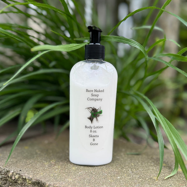A pump bottle of body lotion labeled 'Bare Naked Soap Company Body Lotion - Skeeta-B-Gone' mosquito repellant lotion placed on a surface with green foliage in the background.